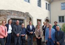 Menschen vor einer hellbraunen Hauswand