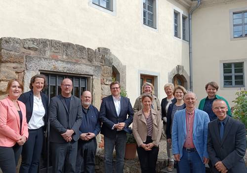AG Historische Städte Menschen vor einer hellbraunen Hauswand