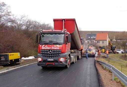 Großer Kipper lädt Baumaterial für Straße ab