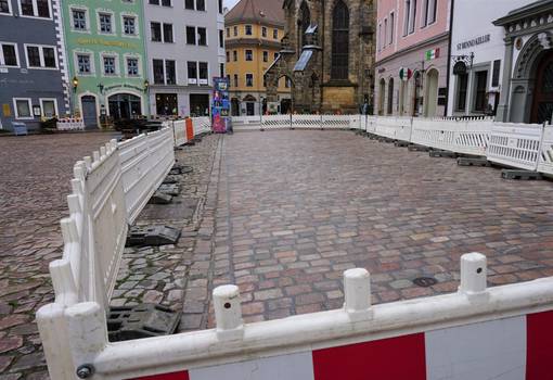 Neu verfugte Pflasterfläche auf historischem Markt mit Bauzaun umzäunt