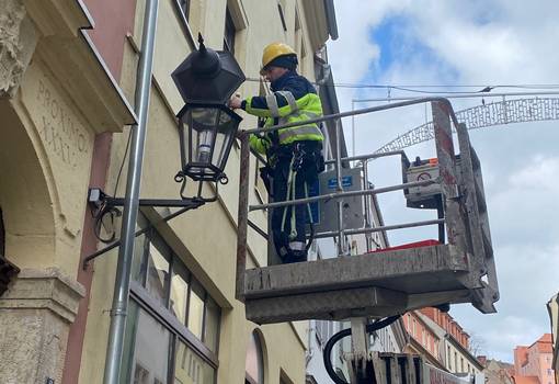 Mann tauscht Lampe auf der Burgstraße aus