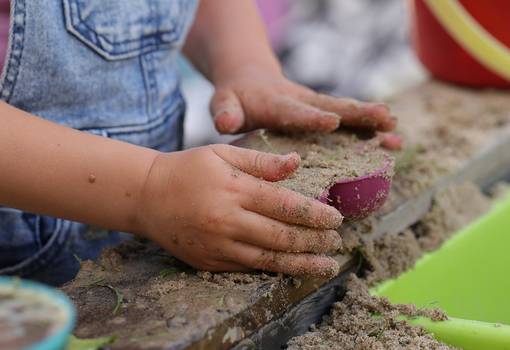 Kinderhände mit Sandspielzeug