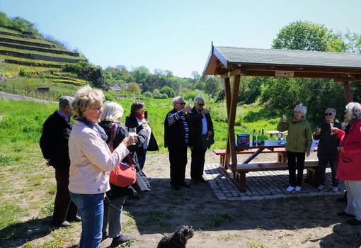 Menschen mit Hund und Sitzgruppe in Weinbergslandschaft