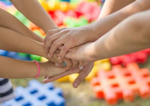 Menschen legen ihre Hände übereinander als Zeichen des Zusammenhalts