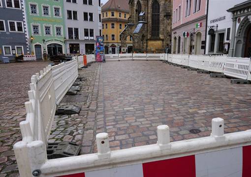 Neu verfugte Pflasterfläche auf historischem Markt mit Bauzaun umzäunt