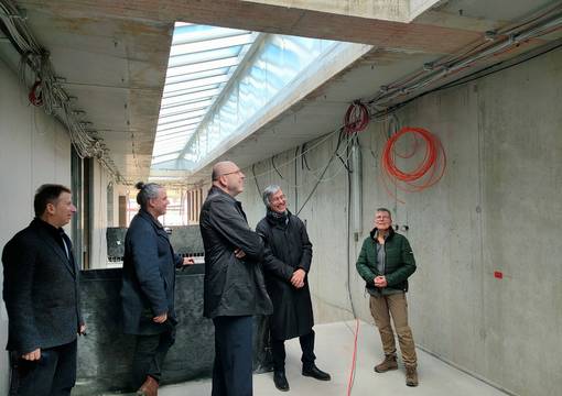 Personen im Gespräch in hellem, teilweise noch im Bau befindlichen Treppenaufgang mit Oberlichtern