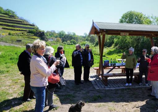 Menschen mit Hund und Sitzgruppe in Weinbergslandschaft
