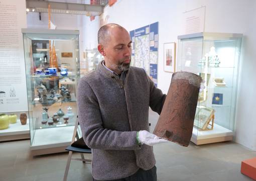 Museumsleiter Tobias Müller präsentiert einen historischen Ziegel