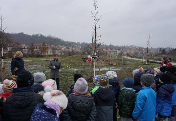 Bürgermeister Markus Renner übergibt im Bürgergarten im Beisein der 1. Klassen der Questenberg-Grundschule die Urkunde an den Förderverein der Schule.